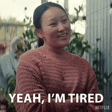 a woman in a pink sweater is smiling and says yeah i 'm tired netflix