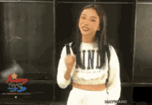 a woman wearing a white sweater that says kind