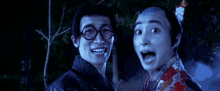a man wearing glasses and a kimono is standing next to another man with his mouth open