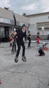 a group of people are jumping in the air in front of a building that says 70 on it