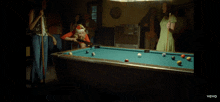 a woman in a santa hat is playing pool