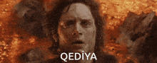 a close up of a man 's face with the word qediya in white letters