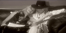 a man in a cowboy hat sits next to a woman