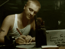 a man writing on a piece of paper that says eminem on it