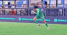 a female soccer player is jumping in the air on a field with a banner that says world sevens football