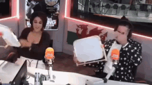 a man and a woman are sitting at a table in front of a microphone .