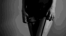 a black and white photo of a woman in lingerie holding a cane .