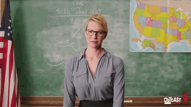 a woman stands in front of a blackboard that says 