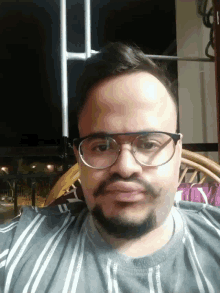 a man with glasses and a beard is wearing a striped shirt with the letter y on it