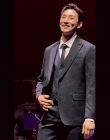 a man in a suit and tie stands on a stage