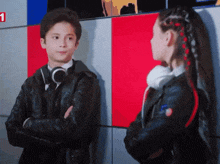 a boy and a girl standing next to each other with the number 1 on the wall behind them