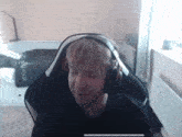 a man wearing headphones is sitting in a chair in a room .