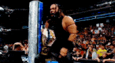 a wrestler is holding a championship belt in front of a crowd with a sign that says mcm on it