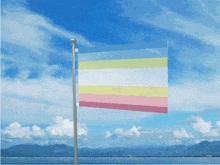 a colorful flag is flying in the wind in front of a blue sky
