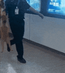 a man with a name tag that says ' a ' on it is walking a dog