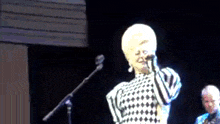 a woman is singing into a microphone on stage