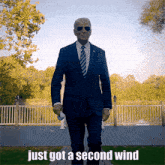 a man in a suit and tie walking with the words just got a second wind