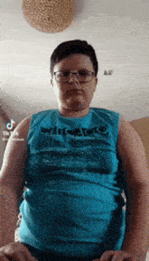 a man wearing glasses and a blue tank top with chicago on it