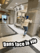 a person standing in a hallway with the words dans face la vie on the bottom