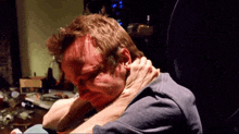 a close up of a person holding a man 's neck in a dark room