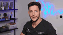 a man with a beard is wearing a black shirt that says dr. mikhail ivanivanski d.d. family medicine