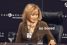 a woman sits at a table with a glass of water and a sign that says casameric on it