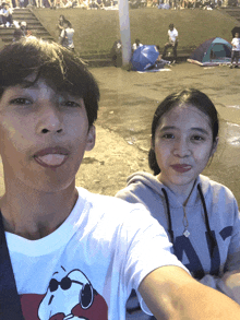 a man and a woman are posing for a picture and the man is wearing a shirt that says snoopy