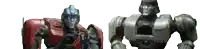 two robots are standing next to each other on a white surface