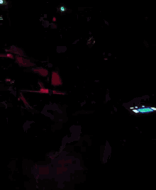 a person playing a violin in a dark room with purple lights