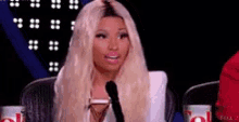 a woman with blonde hair is sitting in front of a microphone .