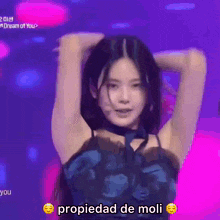 a woman is dancing on a stage with the words propiedad de moli written on the bottom