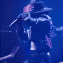 a man in a cowboy hat and a blue jacket is dancing