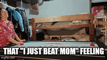 a woman playing a game of air hockey with the caption that " i just beat mom feeling "