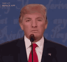 donald trump is wearing a suit and tie and smiling while talking into a microphone .