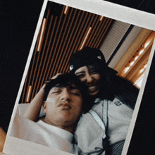 a man and woman are posing for a picture and the woman is wearing a hat with the letter t on it
