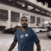 a man is wearing a blue shirt with the number 10 on it .