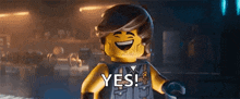 a lego man is smiling and saying yes in a dark room .