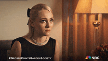 a poster for grosse pointe garden society shows a blonde woman in a black dress