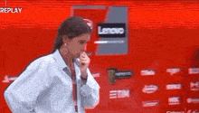 a woman is standing in front of a lenovo sign .