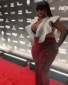 a woman is standing on a red carpet in front of a wall that says bubly on it