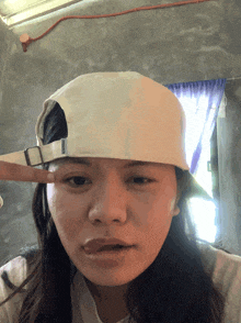 a woman wearing a white baseball cap with the word reebok on it