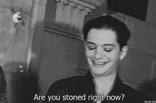 a black and white photo of a smiling man with the words are you stoned right now below him