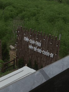 a wooden fence with the words may cua troi hay de gio cuon di written on it