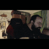 a man with a beard wearing glasses and a black shirt with the word xserve on it