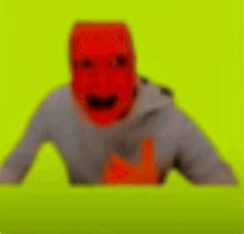 a blurry picture of a person wearing a red mask on a green background .