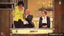 a woman in a yellow jacket is standing next to a man in a tuxedo and two women sitting in chairs .