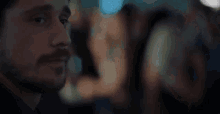 a man with a beard is looking at something in the distance