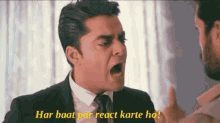 a man in a suit and tie is yelling at another man with the words " har baat par react karte ho " on the bottom