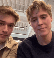 two young men are posing for a picture and one of them is wearing a chain around his neck