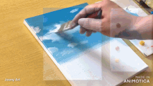 a person is painting on a canvas with the words made in animatica on the bottom right